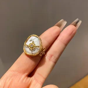 Detailed close-up view of a baroque pearl ring featuring zircon inlay and gold wire wrap