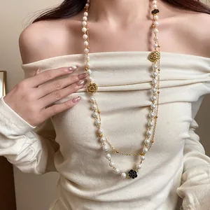Detail shot of a double-layered pearl necklace with vintage camellia charms