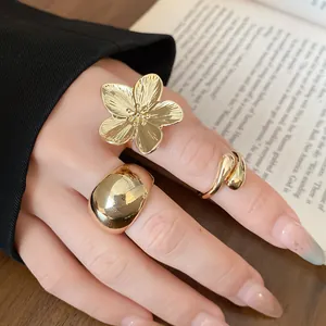 Detailed close-up showing minimalist gold flower and chunky polished dome open ring set on hand