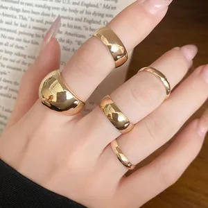 Close-up of a 5-piece minimalist gold-tone smooth metal ring set on fingers