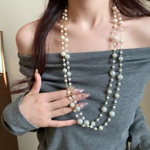 Detail view of an elegant vintage double-layered pearl necklace with golden rose accents