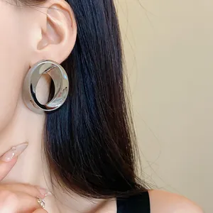 Minimalist silver-tone oversized hollow circular statement stud earring on Asian model