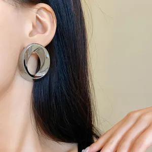 Minimalist circular twisted design silver earring shown on a female model's ear