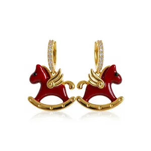 Elegant gold-tone hoop earrings featuring red enamel rocking horse charms with sparkling zircons