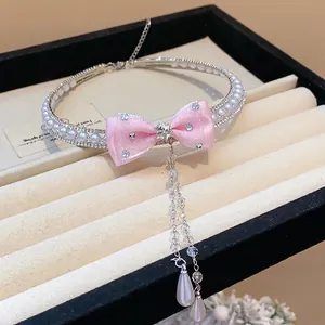 Elegant pearl and zircon choker featuring a pink bow and a delicate tassel pendant