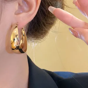 Elegant minimalist polished gold C-shape hoop earrings with silver needles for women