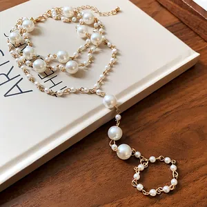 Detaillierte Ansicht eines eleganten mehrlagigen Fußkettchens mit Perlen und Goldkette.