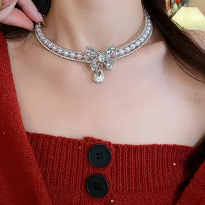 Close-up of the elegant bow-shaped zircon and pearl choker on a model.
