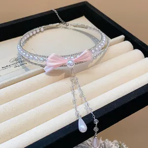 Detailed macro shot of a sparkling zircon pearl choker necklace with a delicate pink bow