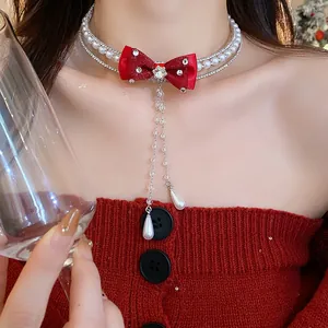 Close-up of elegant double-layer pearl and rhinestone choker with a red bow