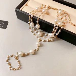 Detaillierte Makroansicht einer luxuriösen mehrlagigen Gold-Fußkette mit Kunstperlen