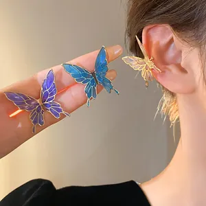 Detailed macro view of colorful butterfly-shaped enamel ear cuffs with gold outlines