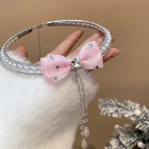 Detailed close-up view of elegant pink bow choker with white pearls and sparkling zircon tassels