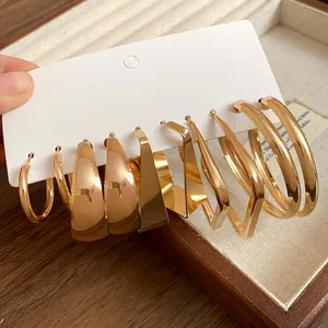 Detailed macro view showing a collection of gold geometric hoop earrings on display