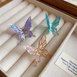 Detailed close-up view of colorful drip oil enamel butterfly ear clips in jewelry box