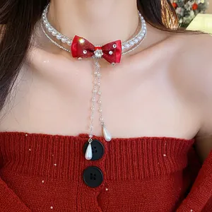 Close-up detail of sparkly zircon pearl choker with elegant red bow and pearl drops