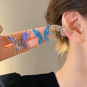 Detailed view of colorful enamel butterfly ear cuffs on an ear
