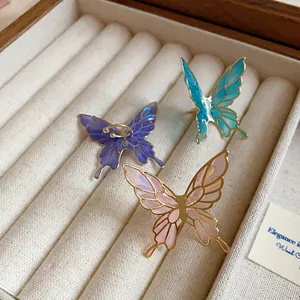 Exquisite close-up detail of three colorful butterfly enamel ear clips in a jewelry box
