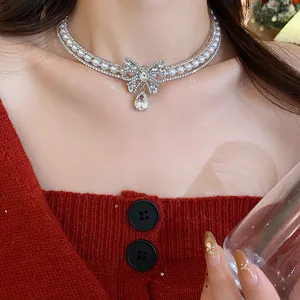 Close-up of elegant bow choker necklace with sparkling zircons and white pearls