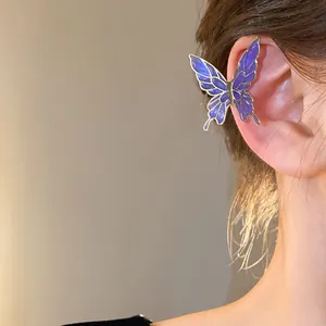 Elegant purple gradient butterfly ear cuff shown being worn on model's ear cartilage.