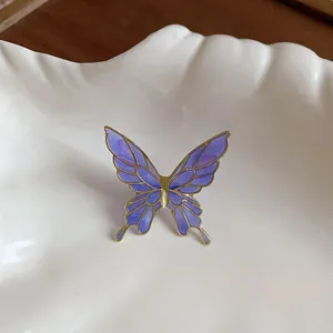 Detailed macro view of purple butterfly ear clip with gold-tone edges and elegant enamel finish