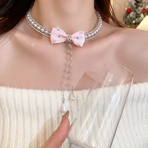 Elegant detail of pink bow choker necklace with lustrous pearls and sparkling zircons