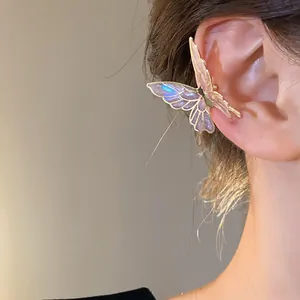 Detailed view of an iridescent purple butterfly ear cuff earring worn on a model's ear