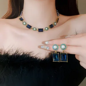 Close-up of vintage French palace style jewelry set with navy blue crystals and pearls.