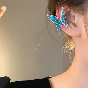 Detail view of a blue fairy butterfly ear cuff featuring delicate gradient oil-dripped wings