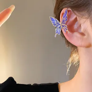 Close-up detail showing elegant purple butterfly oil-drop ear cuff worn on ear.