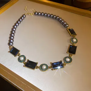 Detailed macro shot of a vintage French style pearl and navy square gem necklace
