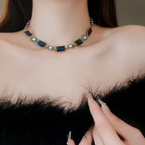 Detailed view of a vintage French court style necklace with blue gems and pearls on a model