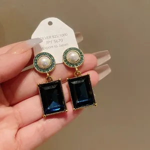 Close-up detail of vintage French style earrings featuring blue crystals and pearls