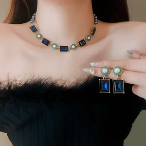 Detail view of vintage French style necklace and earrings set with blue gems and pearls