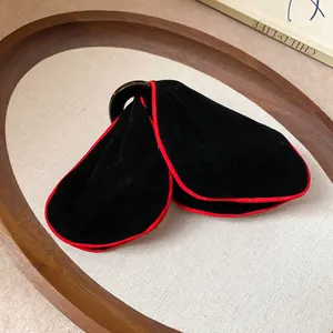 Elegant black velvet triangular hair shark clip featuring a striking red trim detail