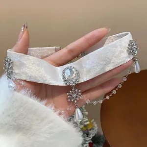 Λεπτομέρεια από λευκό βελούδινο τσόκερ με οβάλ κρύσταλλο και πέρλες σε σχήμα δάκρυ