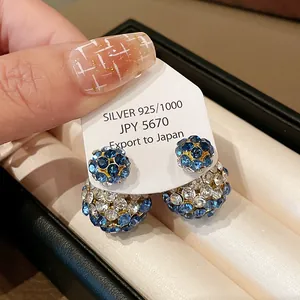 Detailed macro view of elegant double-sided S925 silver earrings with blue crystals