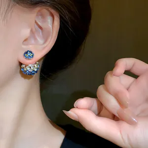 Close-up detail shot of elegant blue and white rhinestone double-sided earrings on ear model.