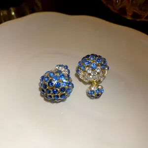 Detailed macro view of sparkling blue and white crystal-paved front-back stud earrings