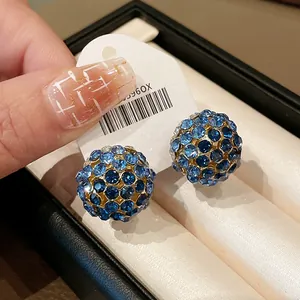 Close-up of blue rhinestone ball earrings with silver needles for women temperament.