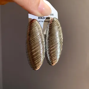 Macro detail of retro textured silver oval stud earrings with an elegant metallic finish