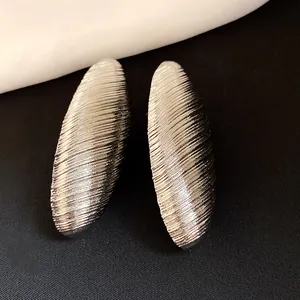 Detailed macro view of retro silver oval earrings with a unique ribbed texture design.