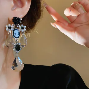 Dettaglio di orecchini vintage in stile palazzo con cammeo e cristalli trasparenti