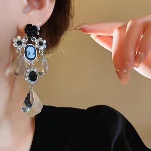 Dettaglio ravvicinato di orecchini vintage a fiore con ago d'argento e strass su modella
