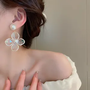 Detailansicht eleganter schillernder Blumen-Perlenohrringe an einem asiatischen Model