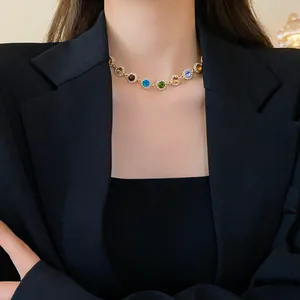 Nahaufnahme einer eleganten bunten Strass-Halskette an einem Model in einem schwarzen Blazer
