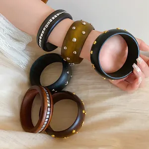 Detailaufnahme von ethnischen Holzhandschmuck mit dekorativen Metallnieten