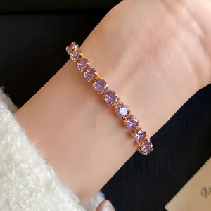 Detailed close-up of 18k gold plated bracelet with round purple zircons on wrist