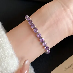 Close-up of elegant 18k gold plated bracelet with purple square-cut zircons on wrist