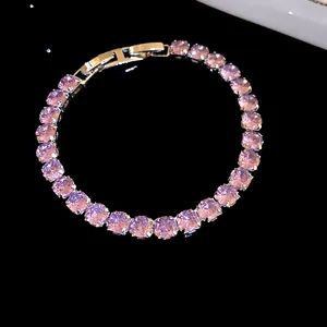 Close-up of 18k gold plated bracelet with sparkling purple zircons and snap clasp.